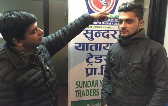सुन्दर यातायातका सञ्चालकहरू थर्मोमिटर परीक्षण गर्दै।